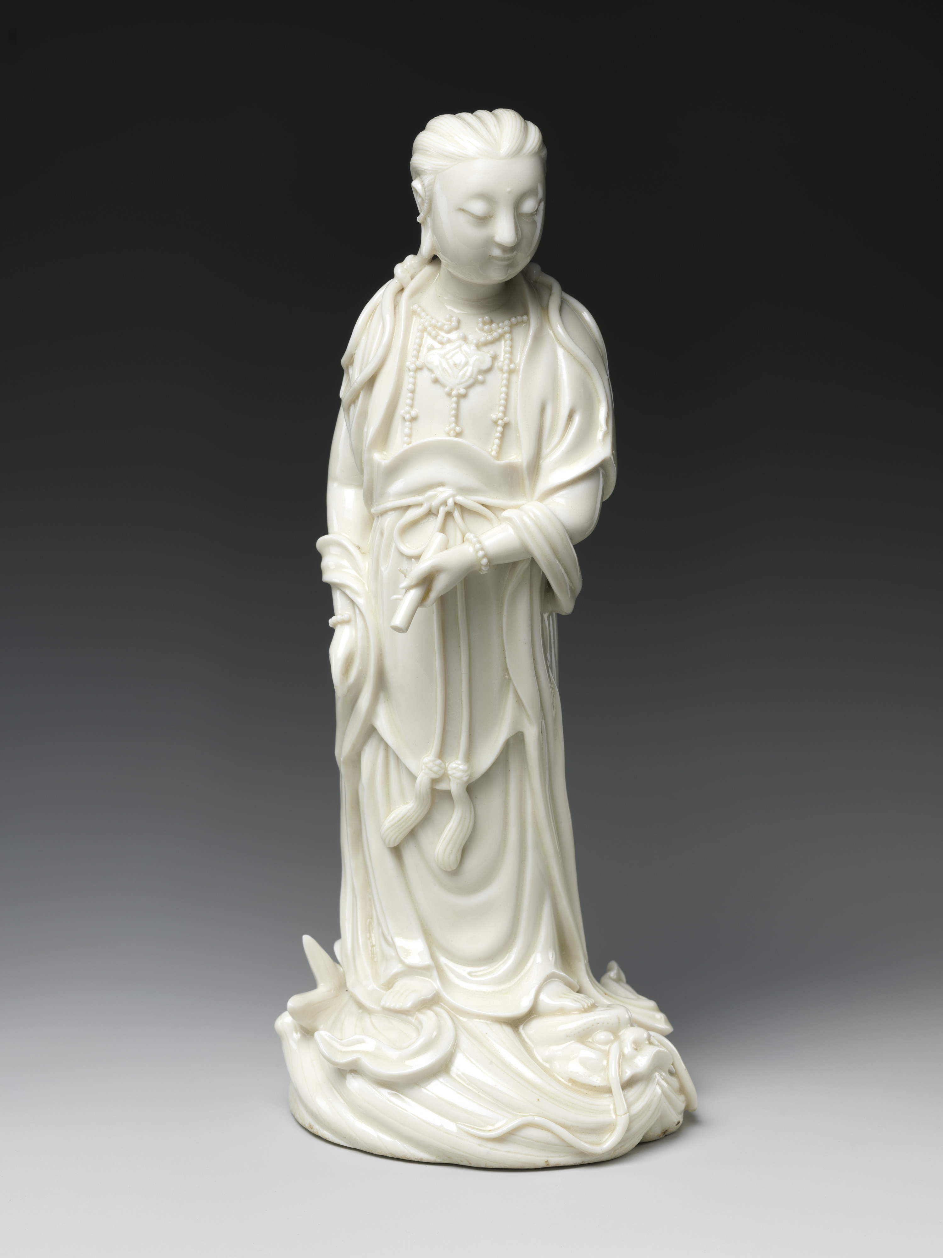 Bodhisattva Guanyin Standing on a Dragonfish, Porcelain with ivory glaze (Dehua ware), 19th century, H. 24.8 cm, The Metropolitan Museum of Art, 50.221.16, Blanc de Chine